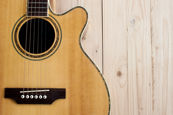 гітарна акустика на дерев'яному столі
 - Фото, зображення