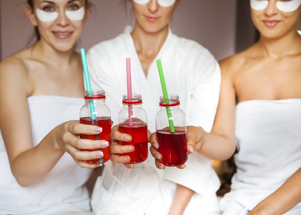 Jóvenes amigas felices bebiendo jugo en el spa y divertirse
 - Foto, Imagen