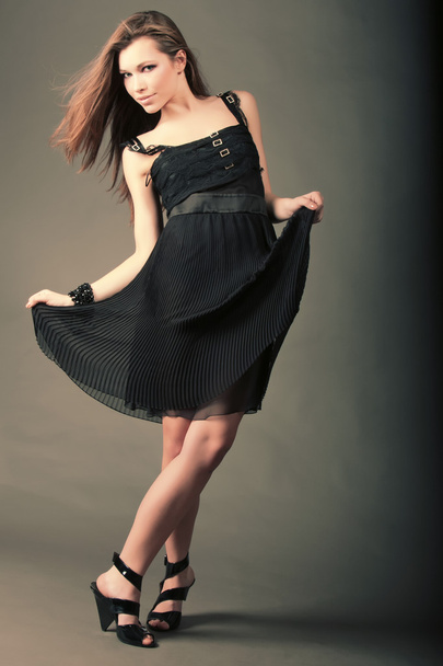 Hermosa chica en un vestido negro está bailando
. - Foto, imagen