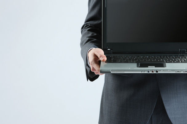 Businessman holding his laptop - Foto, imagen
