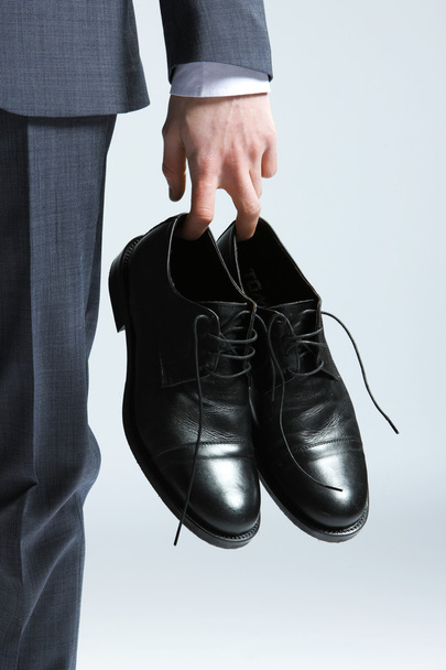 Businessman holding the shoes in hand, close up - Foto, Imagen