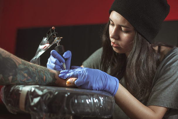 Beautiful brunette girl makes tattoo - Zdjęcie, obraz
