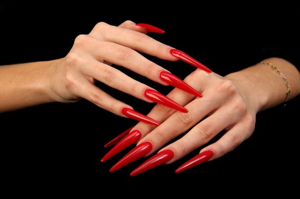 Pretty woman hand with perfect painted nails isolated on black background - Fotó, kép
