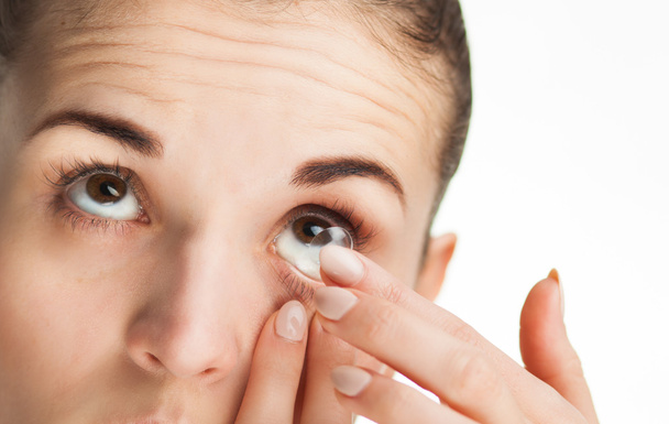 Woman putting contact lens in her eye - Foto, Imagen
