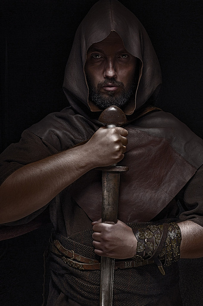 Guerrero vikingo con espada sobre fondo negro sosteniendo espada
 - Foto, Imagen