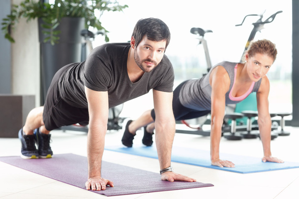Man and woman training together at the gym - Foto, afbeelding