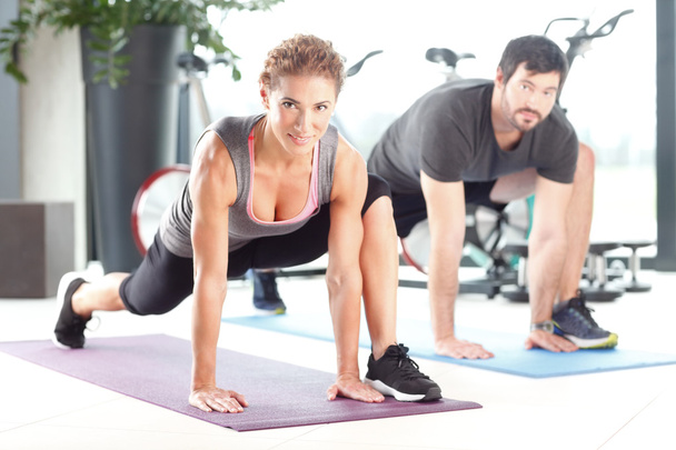 Man and woman working out at the gym - Foto, imagen