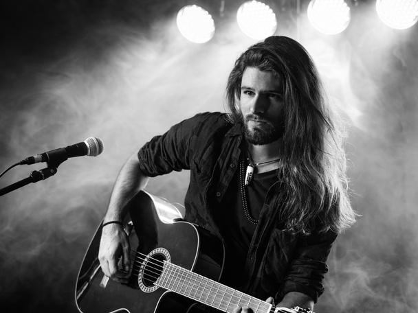 Singing and playing acoustic guitar on stage - Fotoğraf, Görsel
