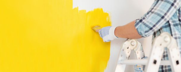 close up of male in gloves painting a wall - Foto, imagen