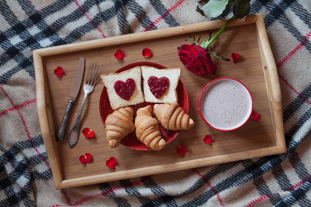 Valentines day romantic breakfast in bed with rose flower and petals. Toasts, croissants, hot chocolate. - Fotoğraf, Görsel