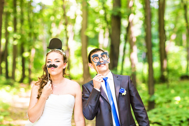 April Fools Day. Bruidspaar poseren met stok lippen, maskeren. - Foto, afbeelding