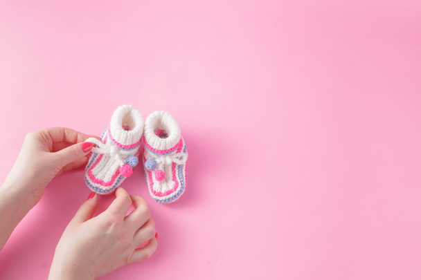 Female hands carefully holing baby shoes - Foto, Imagem