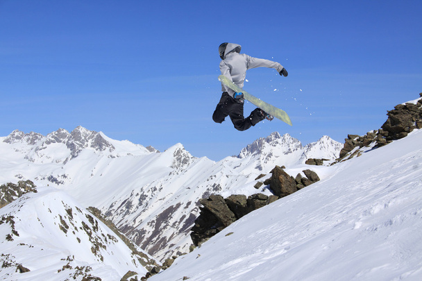 Fliegender Snowboarder auf den Bergen. Extremsport. - Foto, Bild