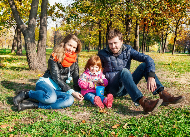 Onnellinen nuori perhe syksyllä puistossa
 - Valokuva, kuva