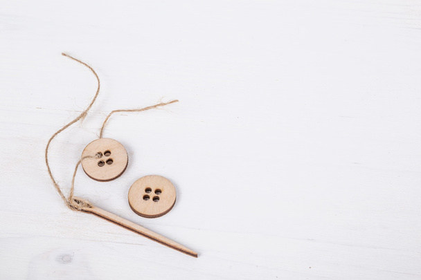 aguja y botones en la superficie de madera
 - Foto, Imagen