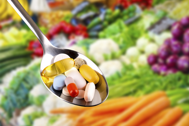 lžíce s léky, doplňky stravy na zeleninu pozadí - Fotografie, Obrázek