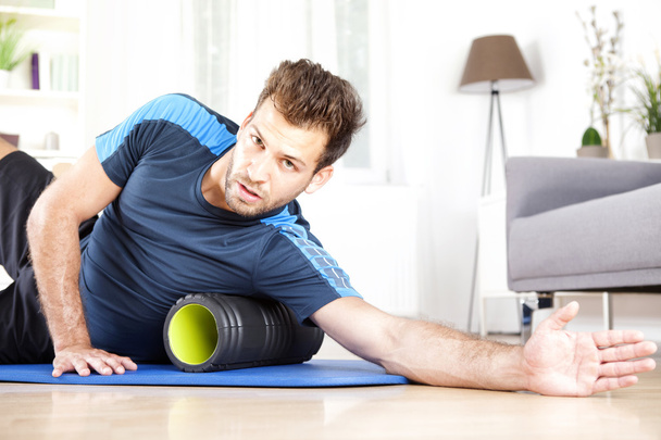 Handsome Guy Lying on Side with Foam Roller - Photo, Image