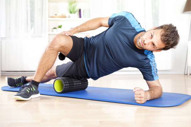 Athletic Man in Side Planking Using Foam Roller - Photo, Image