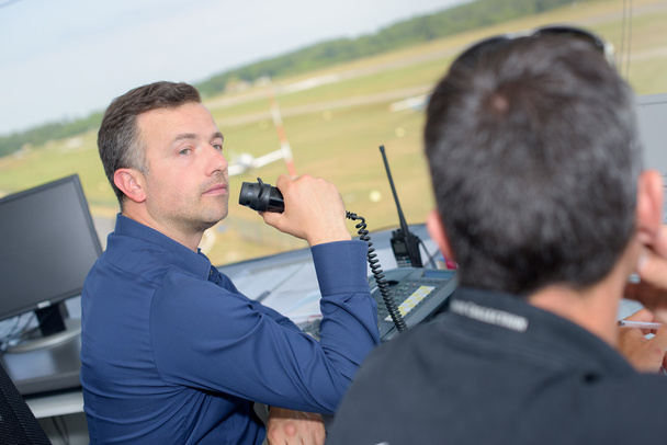 Two men working in airport control tower - Fotó, kép