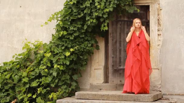 Krásná mladá žena v módní červené šaty pózuje - Záběry, video