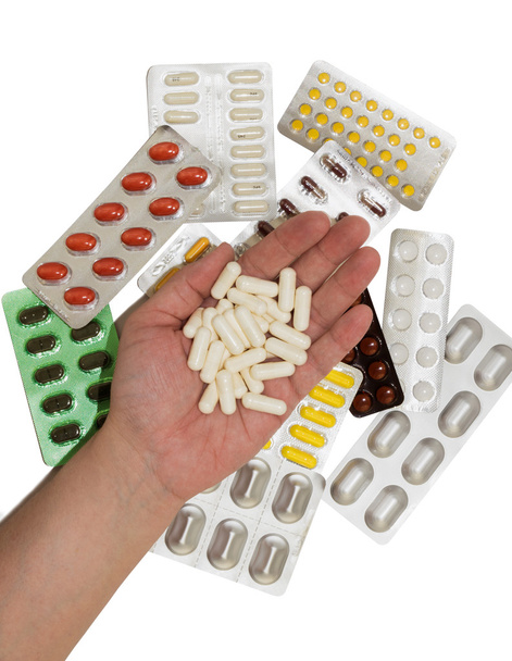 Tabletten in einer Hand und Beutel mit Medikamenten - Foto, Bild