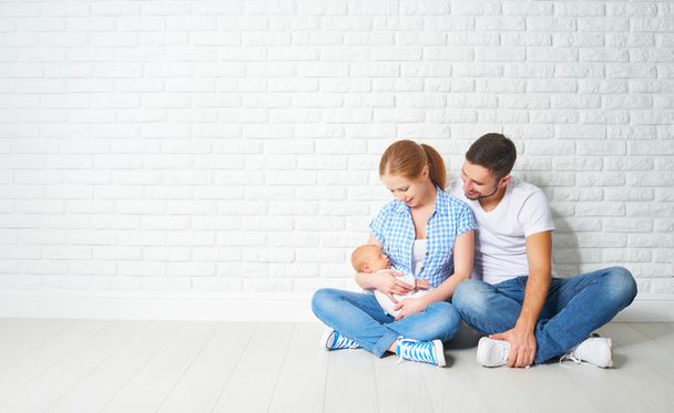 щаслива родина мати, батько новонародженої дитини на підлозі біля ковдри
 - Фото, зображення