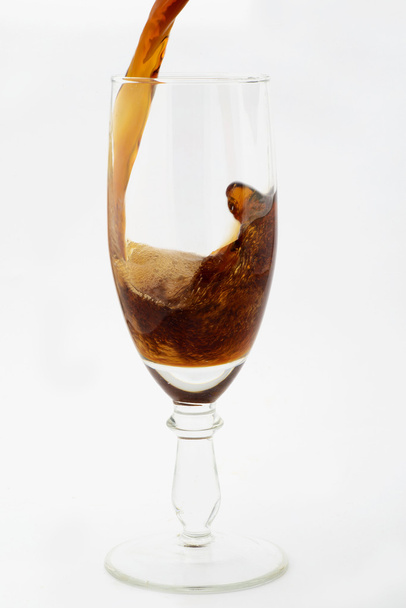 Waaraan koolzuurgas is toegevoegd drankje zoete donkere kleur gegoten in een glas wijn - Foto, afbeelding