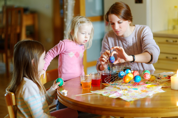 mother and  daughters painting  Easter eggs - 写真・画像
