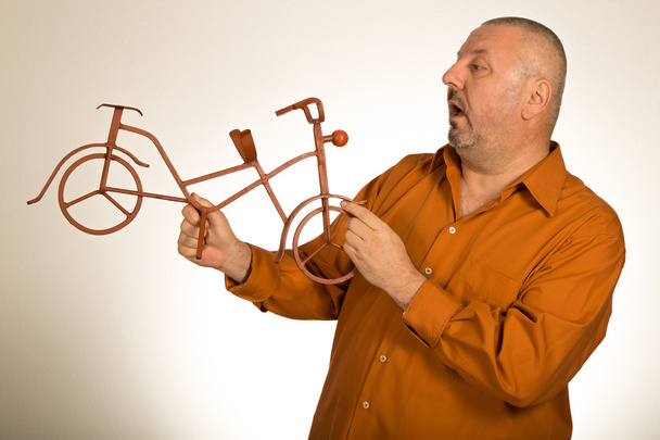 Hombre grande sosteniendo el modelo a escala de la bicicleta / bicicleta
  - Foto, Imagen
