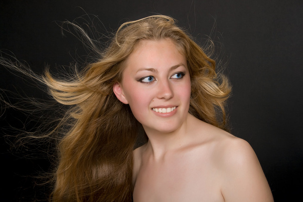 Молодая блондинка с улетучивающимися волосами
 - Фото, изображение