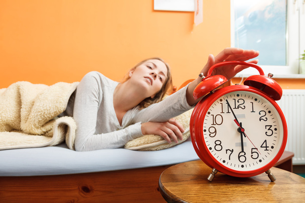 Woman turning off alarm clock - Foto, Bild