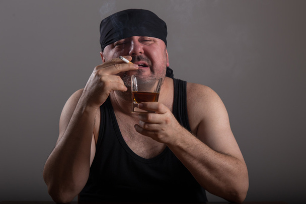 Hombre adulto está fumando cigarrillo y bebiendo whisky
 - Foto, imagen