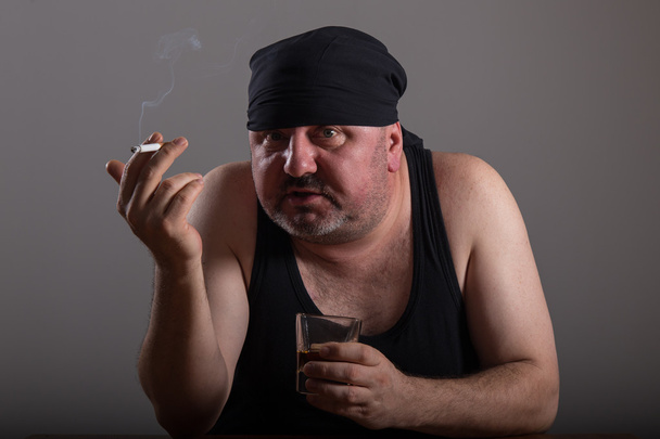 L'uomo adulto sta fumando sigarette e bevendo whisky
 - Foto, immagini
