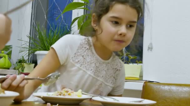 Teen dziewczyna zjada sałata głodny jedzenie na stole - Materiał filmowy, wideo