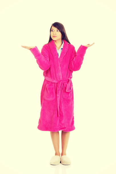 Woman in pink bathrobe showing empty palms. - Foto, Imagen