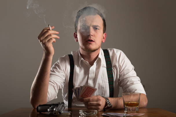 portrait of young man smoking and play poker - Foto, Bild