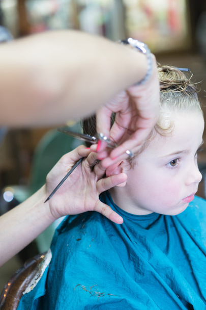 Крупным планом руки стригут волосы мальчика
 - Фото, изображение