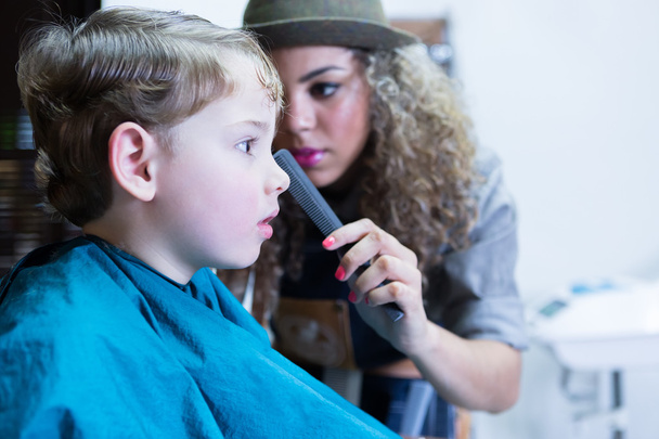 Zbliżenie: młody chłopak siedzący w fotelu fryzjer - Zdjęcie, obraz
