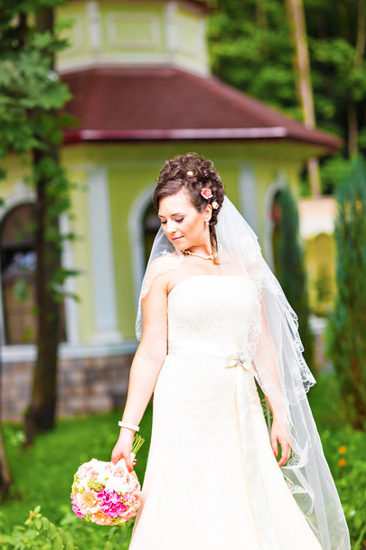 Beutiful bride in white dress holding wedding bouquet - Photo, Image