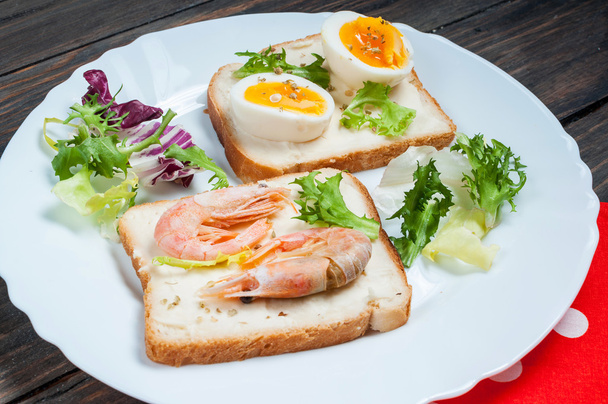 Sandwiches con camarones, huevo, albahaca, ensalada, pan sobre fondo de madera. Deliciosos bocadillos fríos. Comidas vegetarianas. Alimentación saludable
. - Foto, Imagen