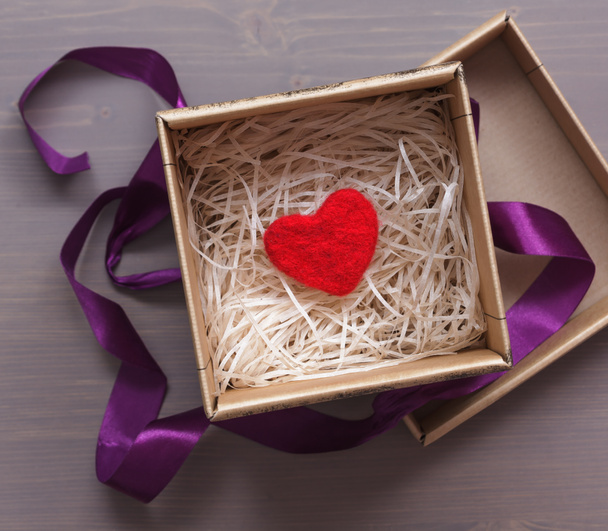Праздничная коробка с красным шерстяным сердцем в подарок
 - Фото, изображение
