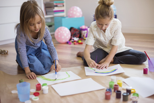 duas meninas fazendo pinturas
 - Foto, Imagem
