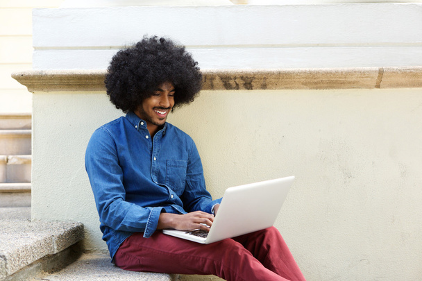 Прохолодний чорний хлопець використовує ноутбук зовні
 - Фото, зображення
