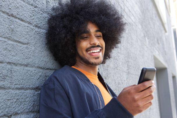 Smiling afro man using mobile phone - Photo, Image