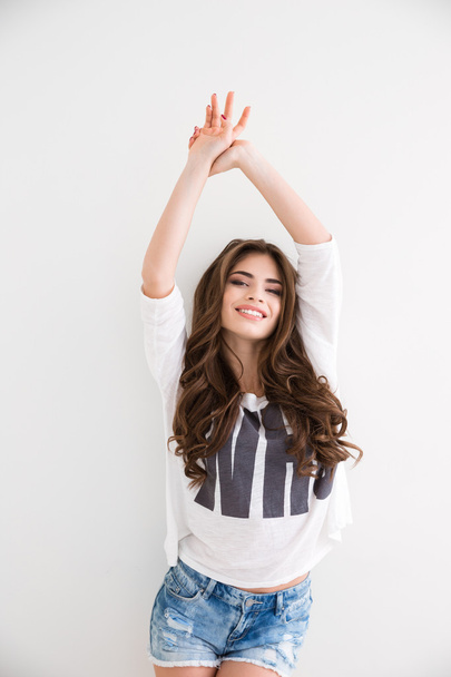 Smiling pretty woman in casual clothes standing with hands up  - Foto, imagen