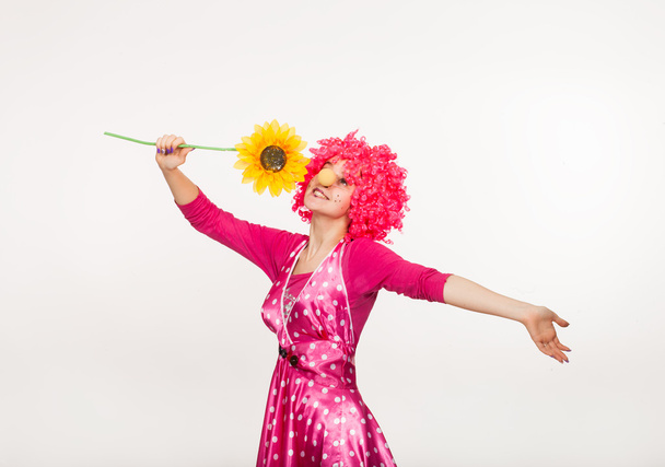 Clown joyeux et émotionnel en perruque rose avec fleur jaune
 - Photo, image
