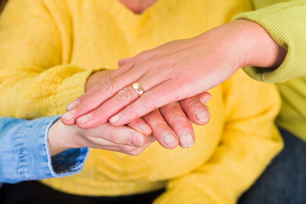 Photo of elderly woman hands supported by young carer - Photo, Image