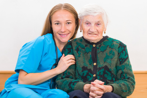 Oudere vrouw en jonge dokter - Foto, afbeelding