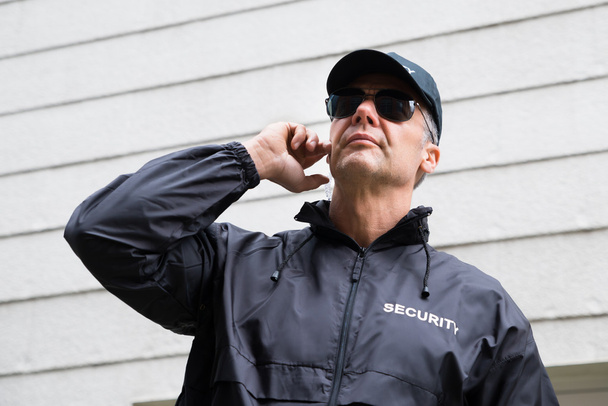 Confident Security Guard Listening To Earpiece - Photo, Image