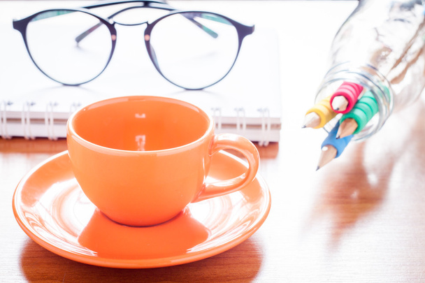 Close up of coffee cup with book and eyeglasses - Zdjęcie, obraz